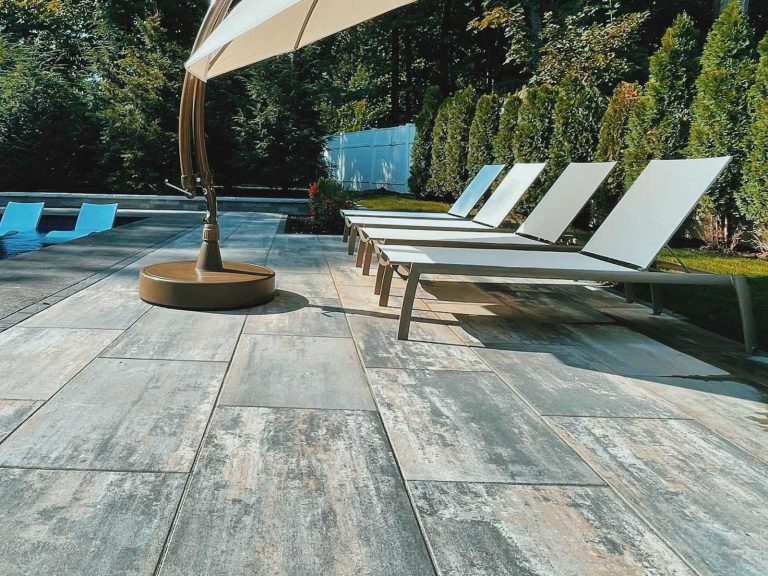 Paver patio pool deck with large slab Unilock pavers in a backyard in Ballston Lake, NY, installed by BlackDiamondDesign Landscaping.