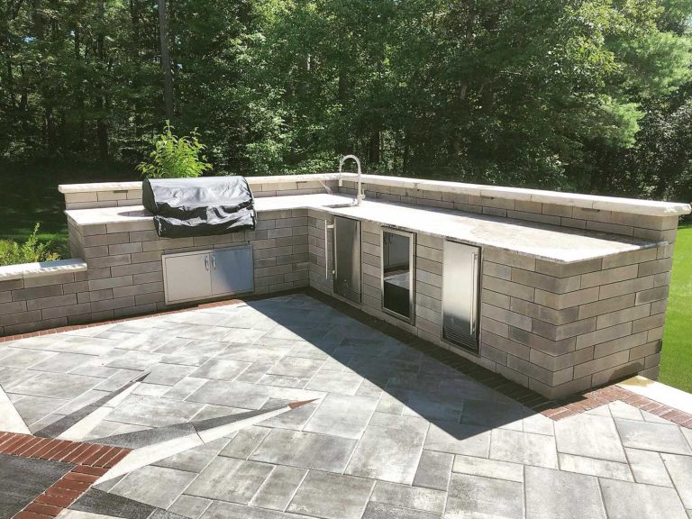 Large outdoor kitchen with a raised back for a sleek, modern look in a backyard in Halfmoon, NY, installed by BlackDiamondDesign Landscaping