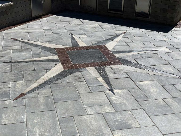 Unique compass made from paver block in guilderland, NY surrounding a gorgeous outdoor kitchen.