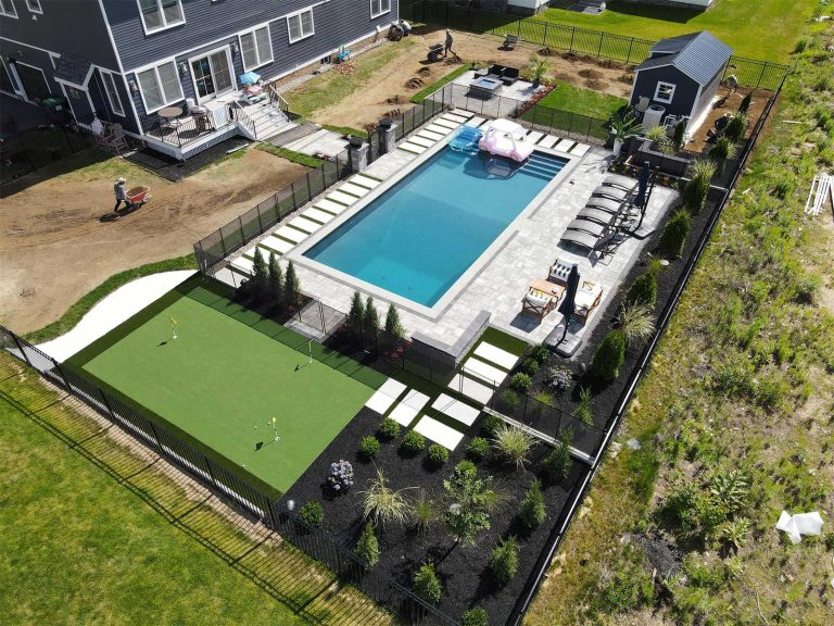 Paver patio around a pool with putting green in ballston lake ny installed by BlackDiamondDesign Landscaping